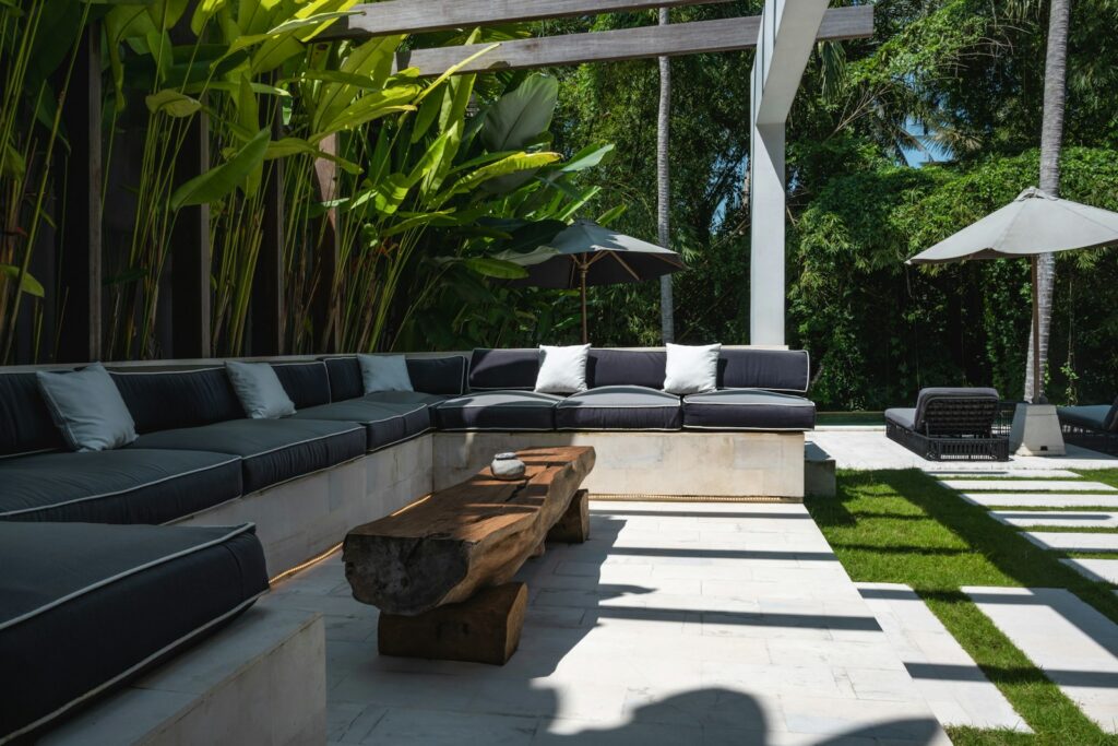 An outdoor living area with a couch, table and umbrellas